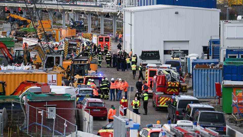 Firefighters, police officers and railway employees stand on a railway site in Munich after an explosion