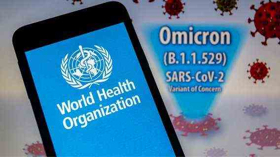 Logo of the World Health Organization (WHO) on a smartphone in front of a visual representation of the newly discovered virus variant Omikron © picture alliance Photo: Andre M. Chang