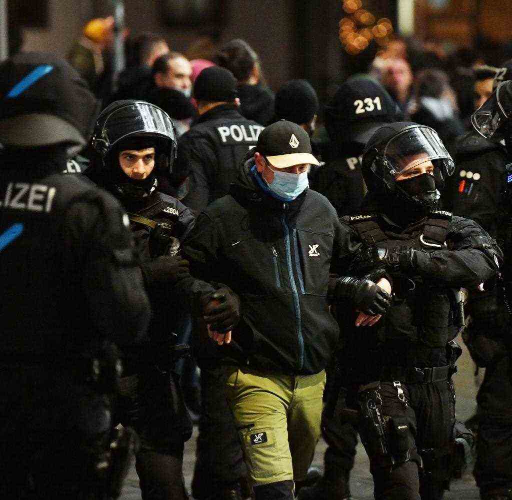 Rhenish police officers lead a man to identify his identity after protests in downtown Erfurt