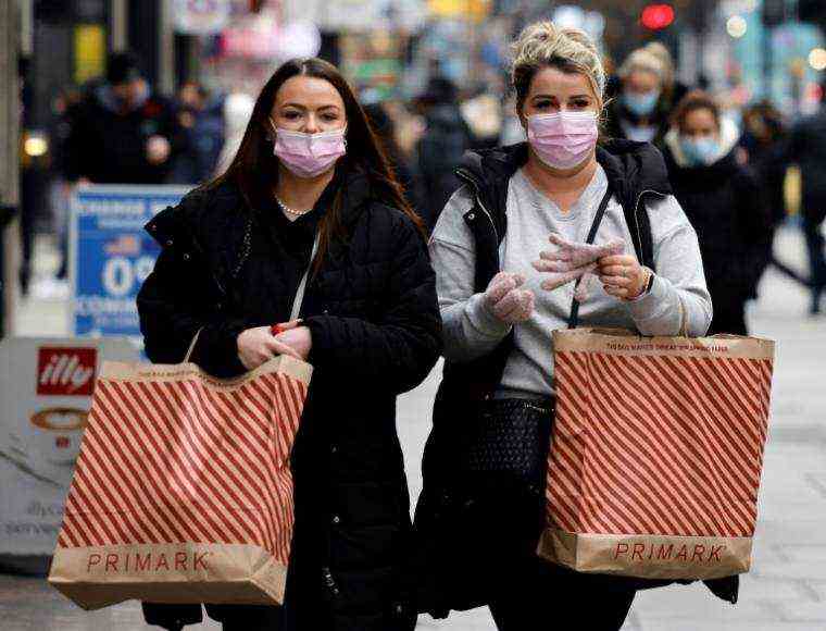 Masked passers-by shop before Christmas in Bond Street in central London on December 21, 2021 (AFP / Tolga Akmen)