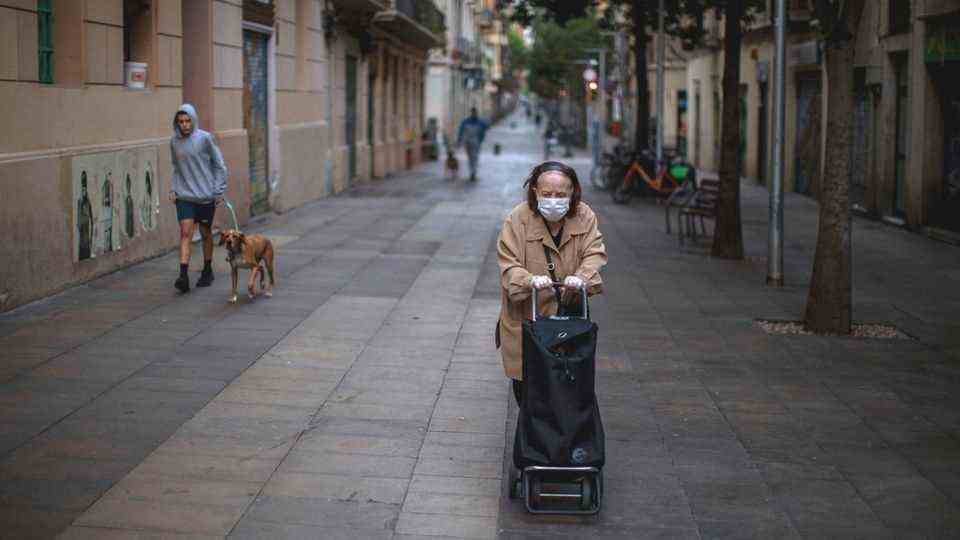 A lonely Barcelona woman pushes her errands cart down an alley in the Poble Sec neighborhood.
