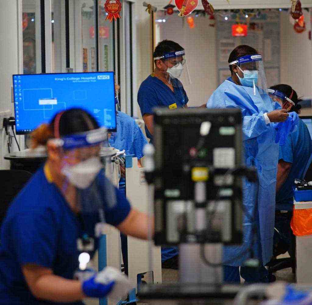 21.12.2021, Großbritannien, London: Medizinisches Personal arbeitet in einem Korridor auf einer Station für Corona-Patienten im King's College Hospital im Südosten Londons