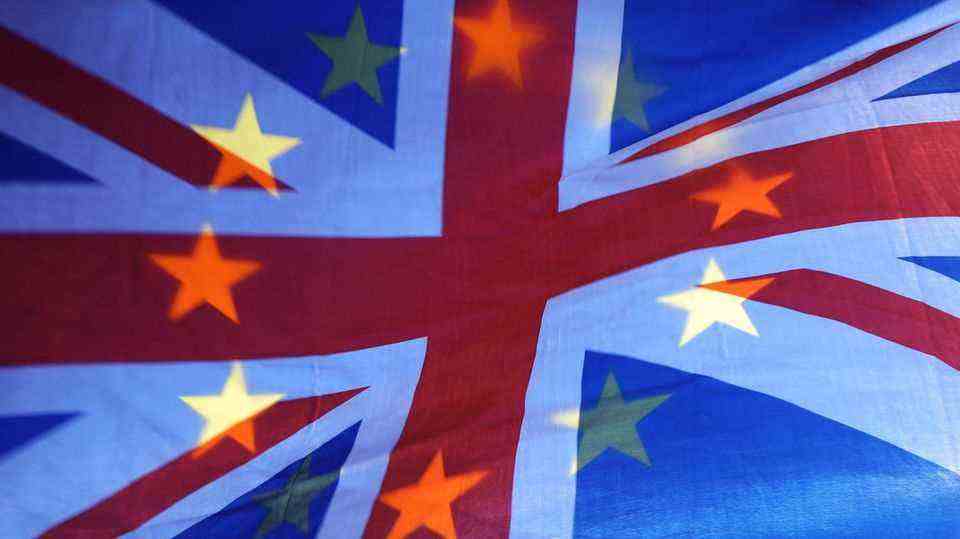 The stars of an EU flag shine through a Union Jack flag