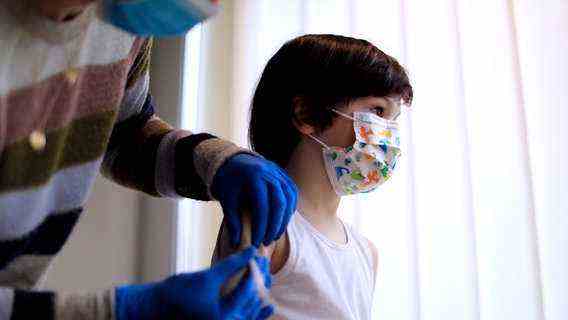 A child with a colorful surgical mask is given an injection in the upper arm.  © picture alliance / Laci Perenyi Photo: picture alliance / Laci Perenyi |  Laci Perenyi