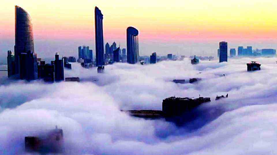 Time-lapse video: high skyscrapers protrude above secondary clouds