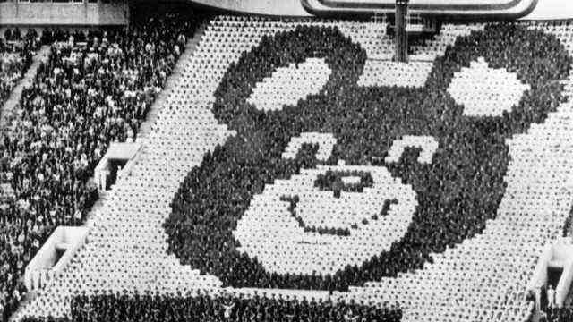 Munich 1972: Countless Mishas, ​​the mascot of the Summer Olympics in Moscow, cavort on the lawn at the opening ceremony of the Summer Olympics in Moscow's Lenin Stadium.  A misha portrait is formed by people in the stands.