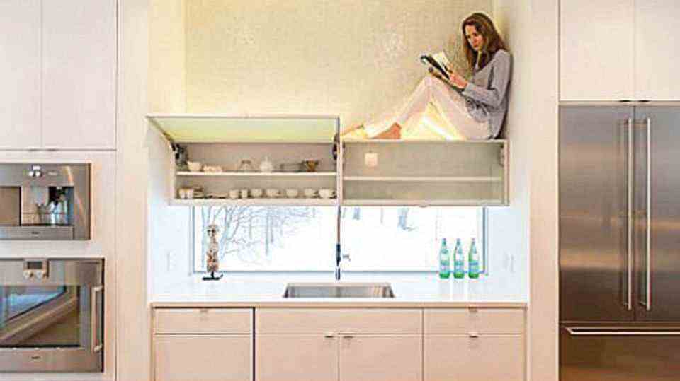 Woman sitting on kitchen cabinet