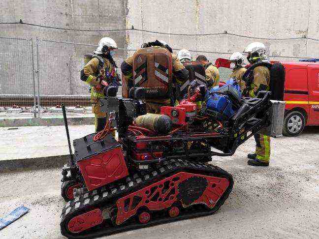 The firefighters of the ELD and their robot REX prepare to intervene.