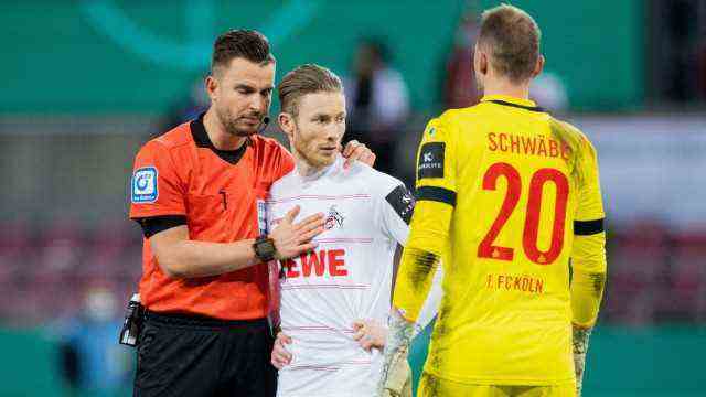 DFB Cup: Referee Daniel Schlager (l) comforts Florian Kainz, who touched the ball twice during his penalty kick, Cologne goalkeeper Marvin Schwäbe is on the right.