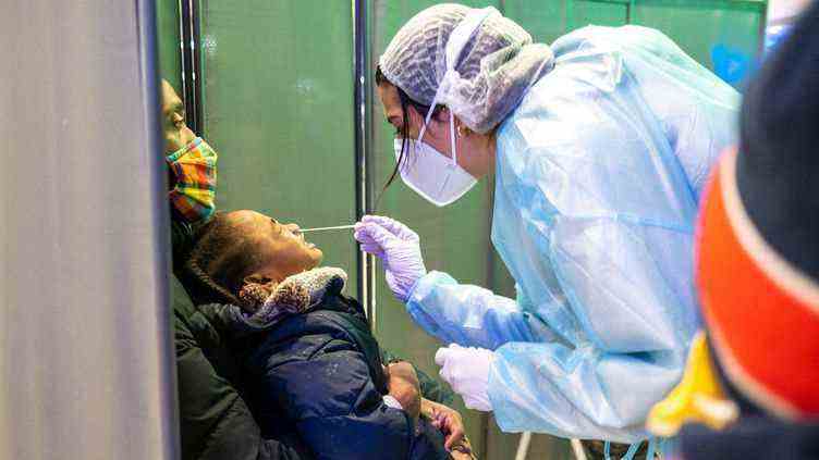 Une pharmacienne pratique un test contre le Covid-19 sur un enfant, le 7 janvier 2022, à Noisy-le-Grand (Seine-saint-Denis). (ALINE MORCILLO / HANS LUCAS / AFP)