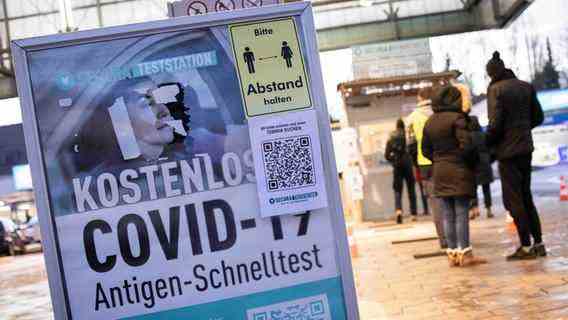 In Hamburg, a sign points to rapid antigen tests, and people are waiting next to it.  © dpa photo: Christian Charisius