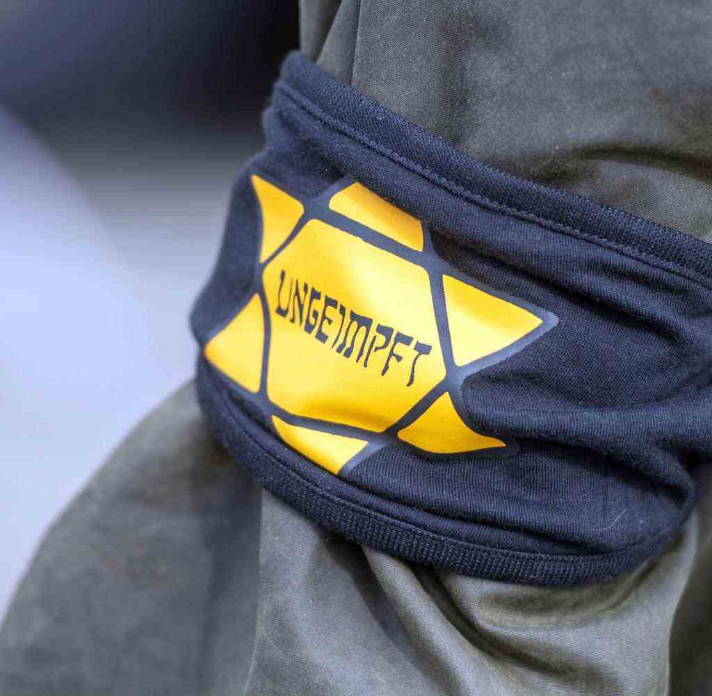 At a demonstration against the pandemic measures, a participant wears an armband with a yellow star, which is supposed to be reminiscent of a Jewish star, with the inscription 