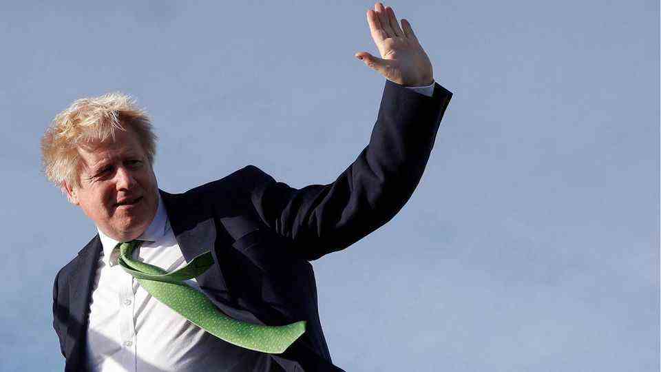 Boris Johnson waves as he boards a plane
