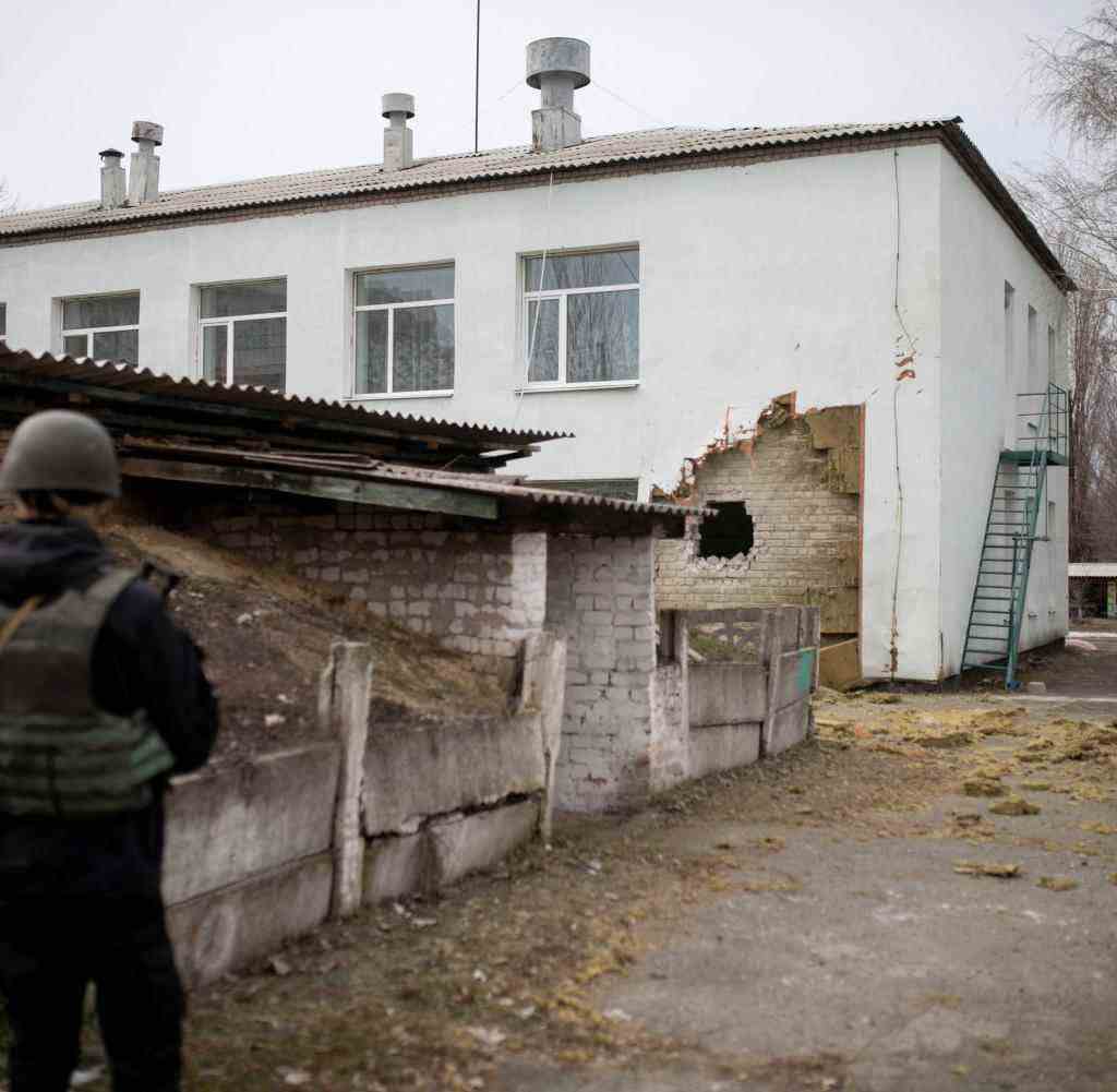 Ein Soldat steht in Stanytsia Luhanska neben einem Kindergarten, der durch den Angriff beschädigt wurde