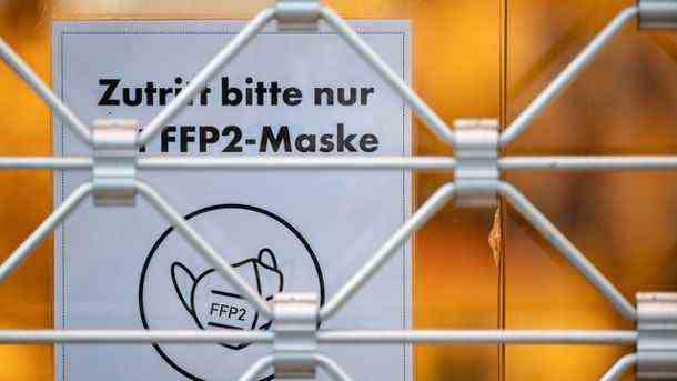 Ein Schild am Eingang eines Geschäfts weist auf das Tragen einer FFP2-Maske hin (Symbolbild): Wann wird in Deutschland gelockert? (Quelle: dpa/Marijan Murat)