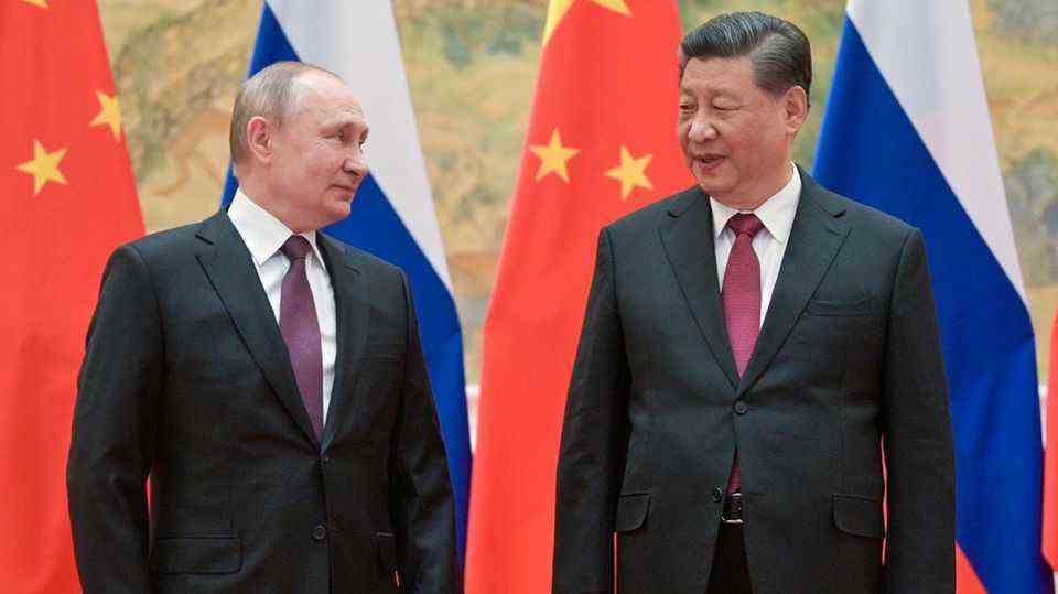 Putin and Xi Jinping in front of Russian and Chinese flags