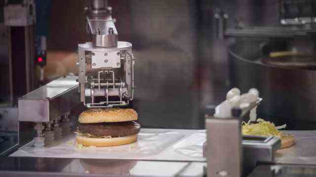 Olympia 2022: Artificial nutrition: A robot prepares a burger in the dining room of the press center in Beijing.
