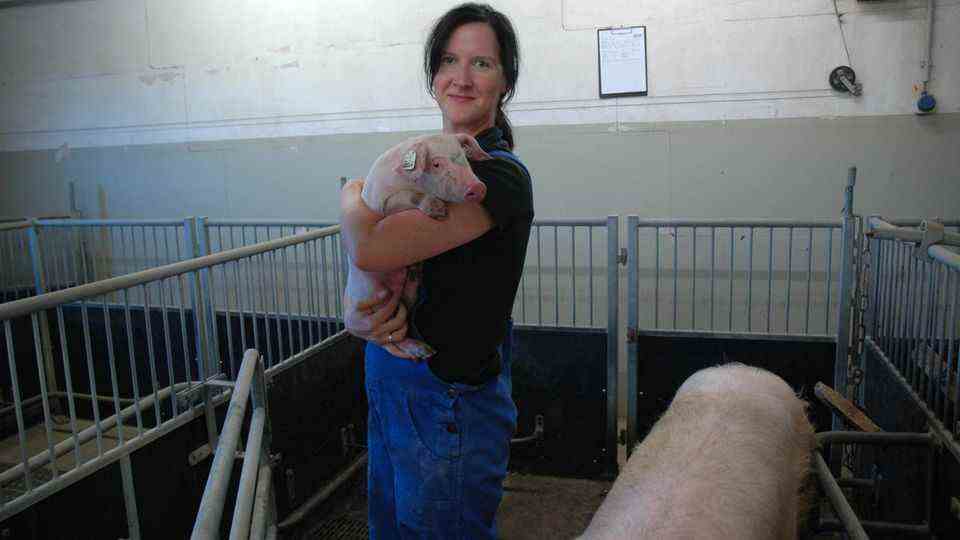 Pig behavior researcher Sandra Düpjan with a piglet in her arms