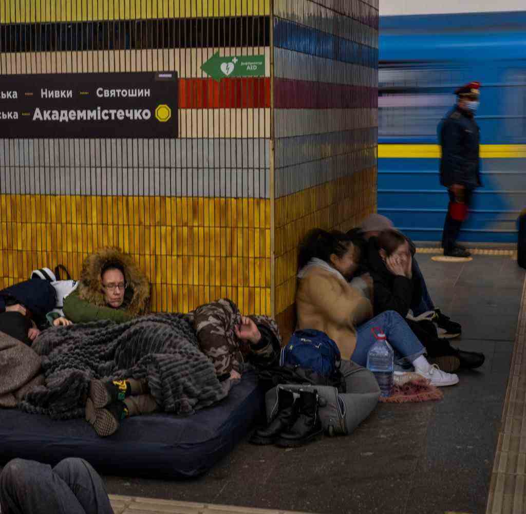 People in Kiev sleep in a subway station used as an air raid shelter
