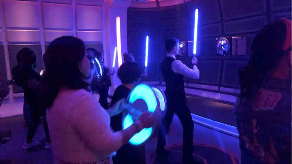 Guests of the Star Wars Hotel Galactic Starcruiser receive lightsaber training
