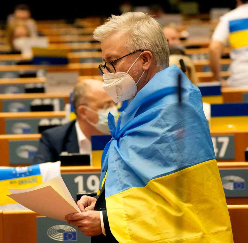 Ein Mitglied des EU-Parlaments mit einer Flagge der Ukraine