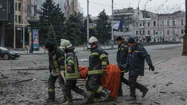 Ukrainische Rettungskräfte tragen die Leiche eines Opfers: Wie viele Menschen bei dem Beschuss ums Leben gekommen sind, ist noch nicht klar. (Quelle: AP/dpa/Pavel Dorogoy)