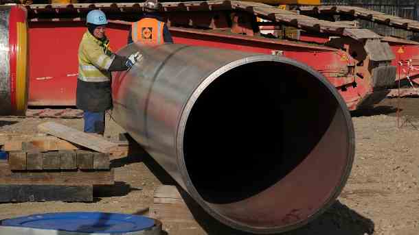 Ein Arbeiter steht neben einem Rohrabschnitt für Nord Stream 2: Der Betreiber der Pipeline kündigte nun allen Angestellten.. (Quelle: Getty Images/Sean Gallup)