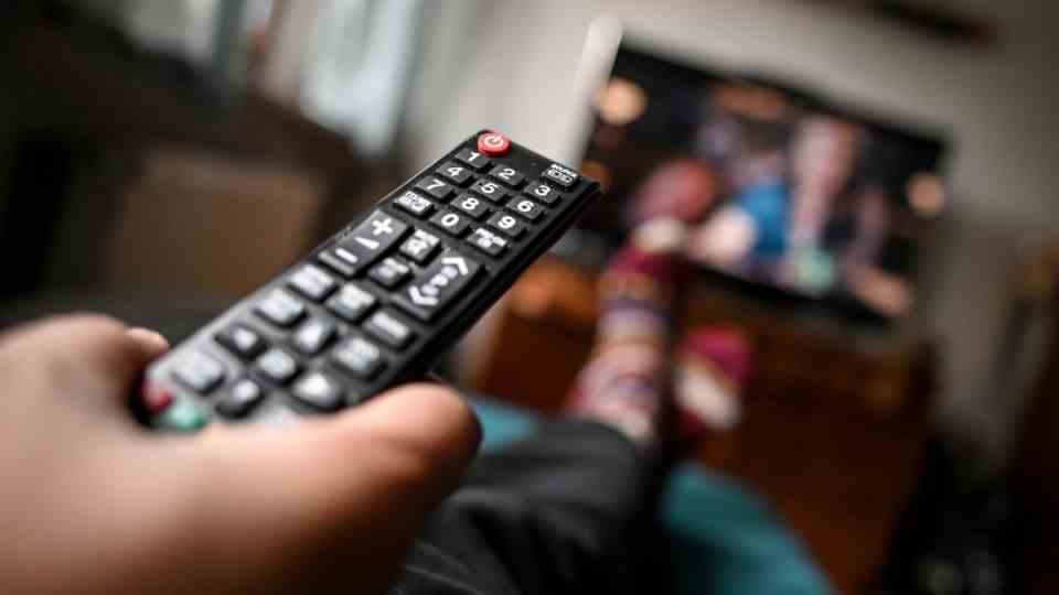 A remote control is held in the hand