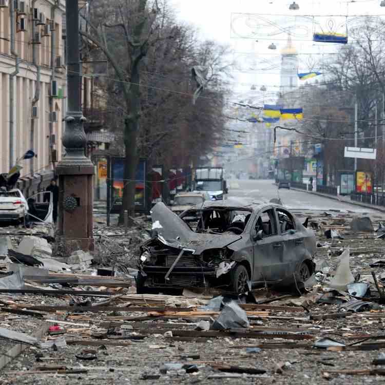 Une carcasse de voiture calcinée devant le siège de l’administration d’État de la région de Kharkiv (Ukraine), détruit par un missile de l'armée russe, le 1er mars 2022. (VYACHESLAV MADIYEVSKYY / NURPHOTO)