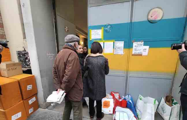 Donors are welcomed by Iryna, in front of the door of the premises, in the colors of Ukraine.  Paris, March 3, 2022
