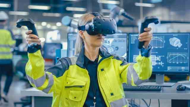 Virtual Reality: Eine Mitarbeiterin von Siemens demonstriert eine Virtual-Reality-Brille. Aus der Ferne lassen sich auch Produktionsanlagen warten.