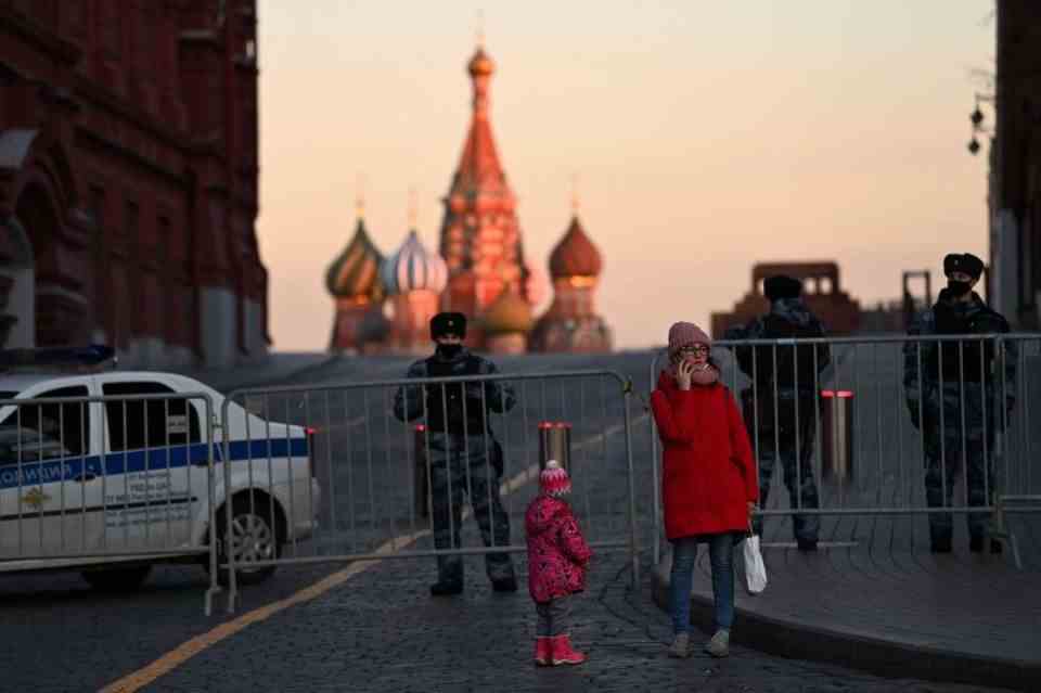 Police officers block the way of a mother and her child.  Fearing protests directly in front of the Kremlin walls, Vladimir Putin has had Red Square sealed off for days, the central square of the Russian capital, where life normally pulsates. 