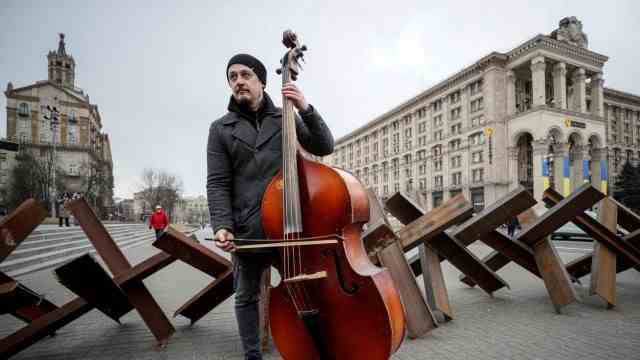 Concert on the Maidan: A bass player in front of the tank barriers in the center of Kiev.