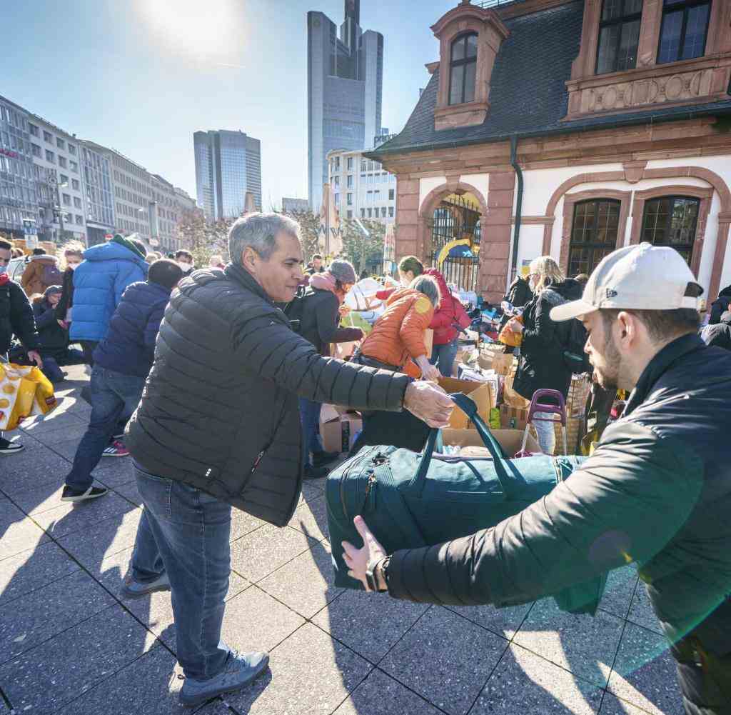 Volunteers in Frankfurt/M.  form a human chain to pack and sort donations in kind