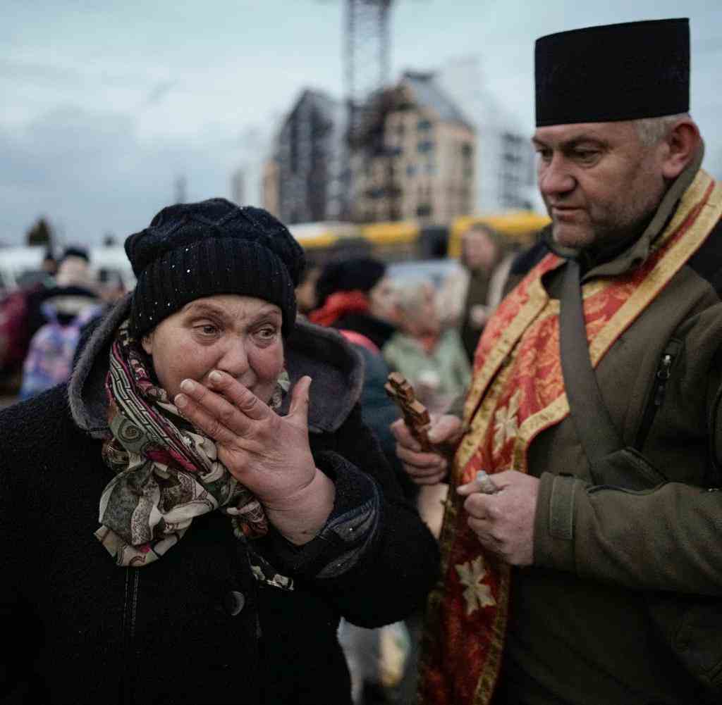 Ein Priester der Armee beruhigt eine weinende Ukrainerin in Irpin
