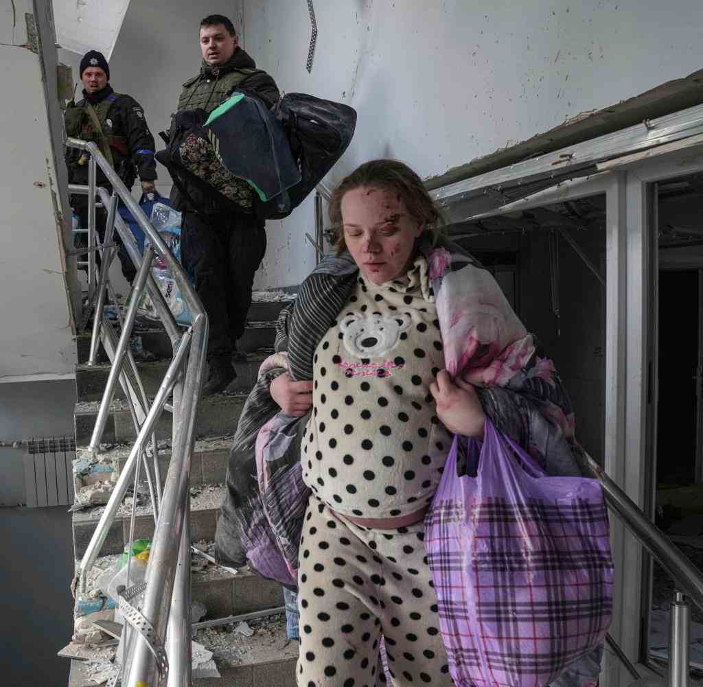 Eine hochschwangere Frau flüchtet aus dem zerstörten Krankenhaus in Mariupol