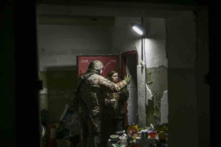 A Ukrainian soldier and a resident in an underground shelter in Irpin, north of Kiev, on March 10, 2022 (AFP/Aris Messinis)