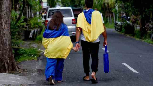 Stranded in paradise: Ukrainians have also gotten stuck in Bali, like this couple, who are using the Ukrainian national flag in Denpasar to draw attention to the situation in their homeland.