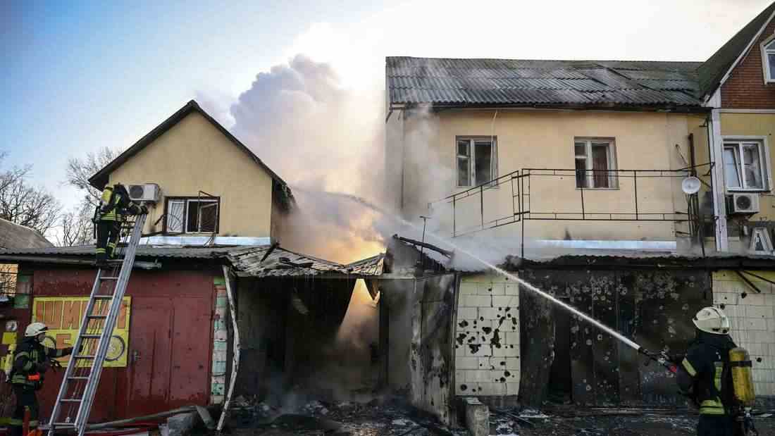 Einsatzkräfte löschen am 12. März einen Brand in einem bombardiertes Wohnhaus in Kiew.