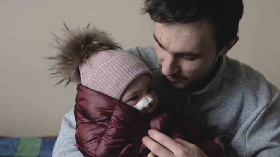 Ukraine refugee Serhi Stotsky holds his wounded daughter in his arms.