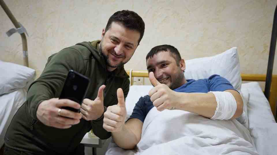 Ukraine President Zelenskyy takes a selfie with a wounded soldier