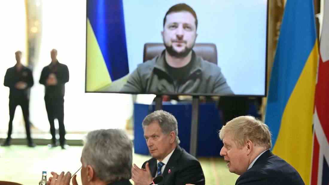 Der britische Premierminister Boris Johnson und weitere Teilnehmer applaudieren nach einer Videoschalte des ukrainischen Präsidenten Wolodymyr Selenskyj.