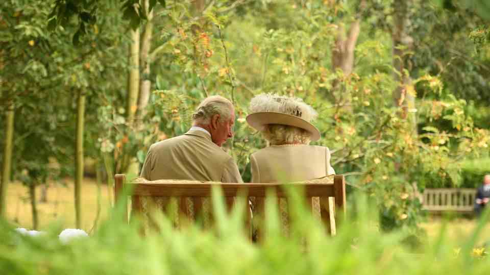 Camilla and Charles seated on a bench