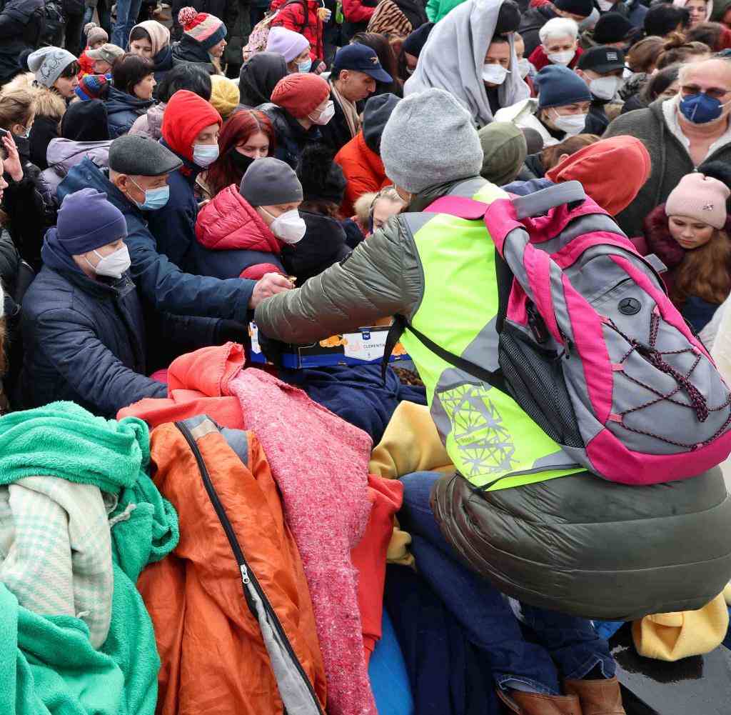Menschen, die aus der Ukraine geflohen sind, warten vor dem Amt für Migration in Hamburg und werden von freiwilligen Helfern versorgt