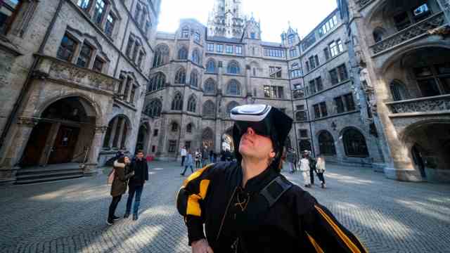 City tours: And what did it look like here in the past?  One of the historically dressed city guides with virtual reality glasses in the inner courtyard of the town hall.