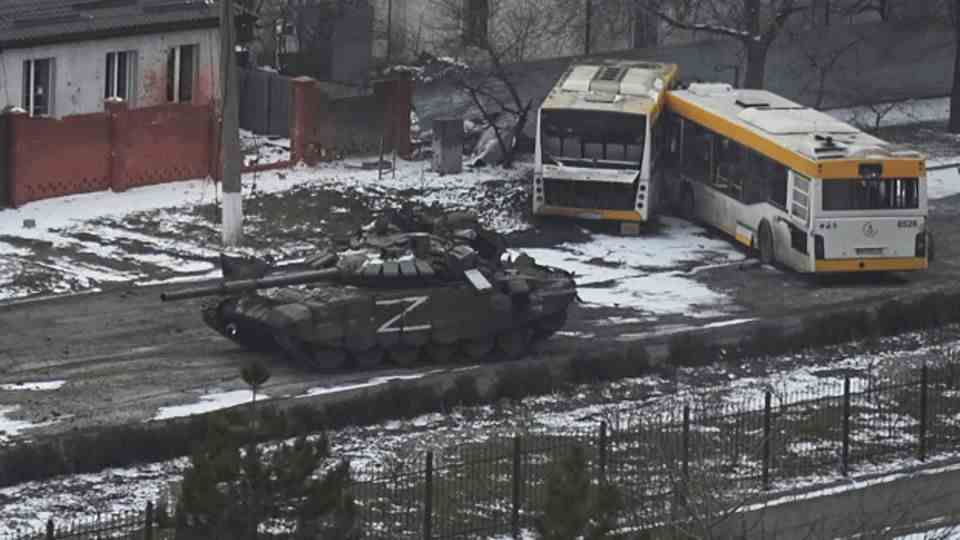 Russian Army tanks move through a street on the outskirts of Mariupol