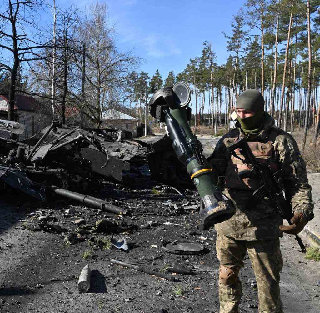 Ein ukrainischer Soldat vor einem zerstörten russischen Panzer – dank ausländischer Hilfe