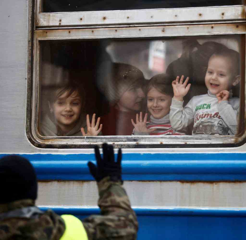 Ein polnischer Soldat winkt Kindern, die in einem ukrainischen Zug in Przemysl in Polen ankommen