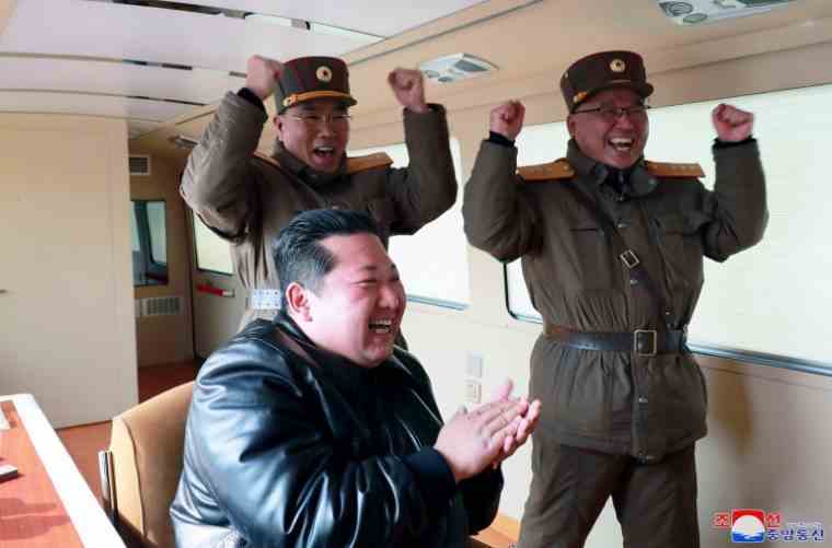 Photo released on March 25, 2022 by North Korea's Kcna news agency of North Korean leader Kim Jong Un (c) applauding during a Hwasong-17 intercontinental ballistic missile launch at an unspecified location in North Korea on March 24, 2022. (KCNA THROUGH KNS/STR)