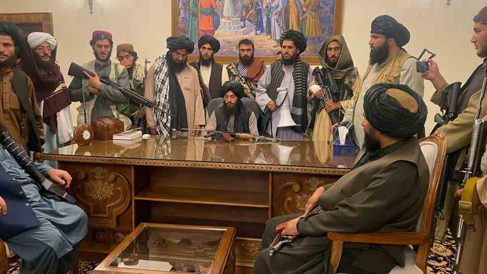 Taliban fighters sit in a room in the Presidential Palace in Kabul, Afghanistan